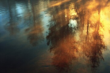 Naklejka premium Sunlit trees reflected in dark water, abstract colors, blurry movement