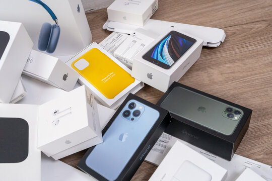 Rostov, Russia - April 04, 2022: A large pile of Apple product boxes devices including iPhones, iPad, AirPods Max are scattered across wooden floor, creating consumer electronics unboxing haul concept