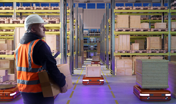 Warehouse automation, worker manages inventory with tablet while robots transport boxes, smart logistics, storage optimization and supply chain operations