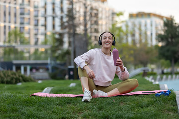 Obraz premium Young woman enjoying break hydrating after fitness workout