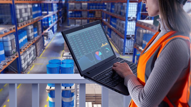 Warehouse analytics, Inventory control. Female logistics specialist reviews stock data on laptop from mezzanine level, monitoring storage operations and supply flow inside distribution center.