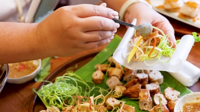 Hands Preparing Vietnamese Nem Nuong Spring Rolls with Pork and Vegetables