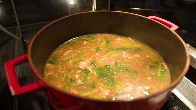 Hot Thai Seafood Soup Simmering in a Red Iron Pot