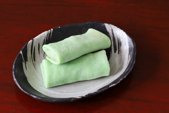 Close up shot of some homemade Indonesian coconut pancake "Dadar Gulung" on plate in natural light.
