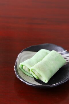 Close up shot of some homemade Indonesian coconut pancake "Dadar Gulung" on plate in natural light.