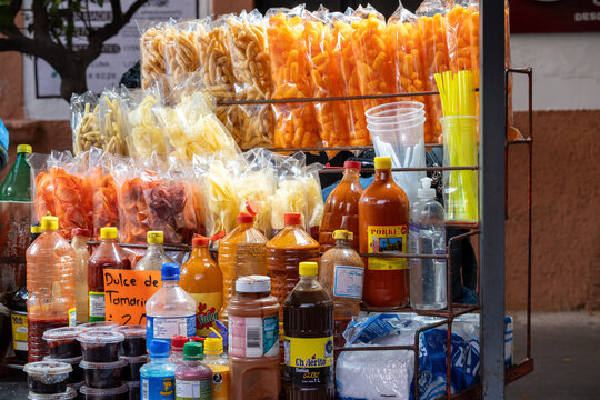 Zapopan, Mexico - February 28 2026: Vibrant Mexican street food stall in Zapopan showcasing a diverse array of packaged snacks, traditional spicy sauces, and refreshing beverages