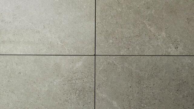Gray stone tile texture with grout lines, minimalist ceramic surface background, architectural floor detail, candid style video, high quality stone wall material.