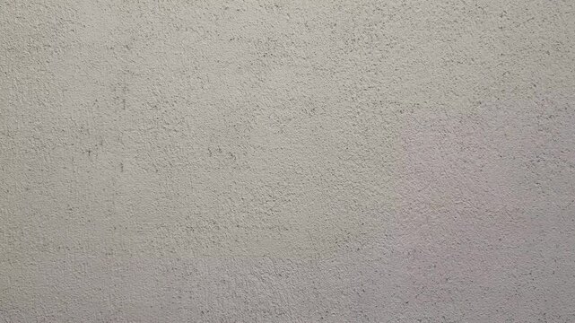 Plaster wall texture background, gray cement surface detail, industrial concrete finish, candid style video, minimalist architectural backdrop, grainy plaster material.