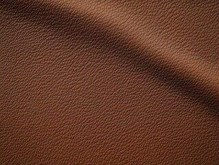 Fototapeta premium close-up of textured brown leather surface with fine grain and a soft diagonal fold conveying a warm, cozy tactile feel