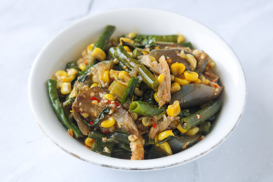 A bowl of Sayur Rica Rodo, a traditional Manadonese vegetable dish from North Sulawesi. It consists of sauteed eggplant, corn kernels, long beans, and shredded fish.