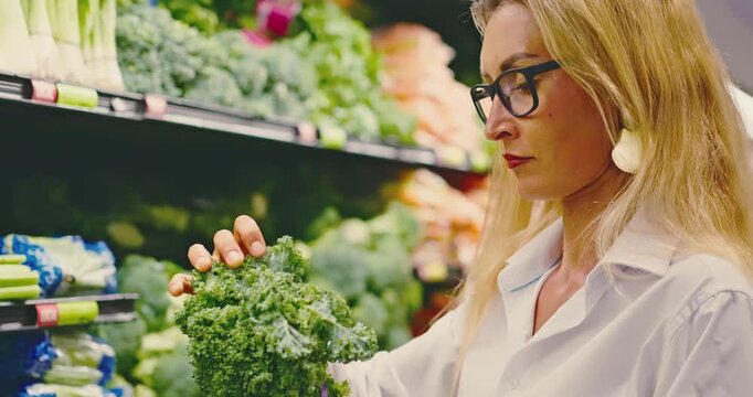 Woman Choosing Fresh Kale in Grocery Store Produce Aisle