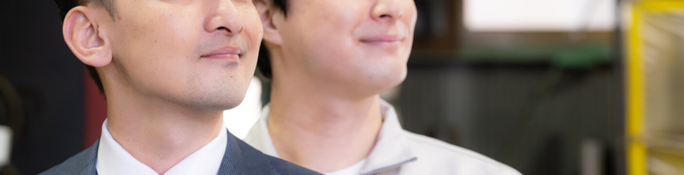 工場で未来を笑顔の横顔で見つめる、見上げるビジネスマンと作業員と2人チームの信頼関係　信金営業や商工会の営業マンと中小企業、 m＆aなどのイメージ　顔無し