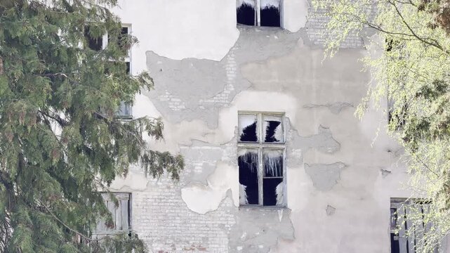 Abandoned building facade with broken windows panning