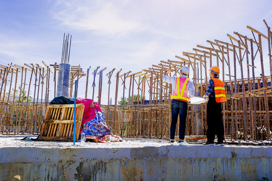 Structural engineer, architect and foreman worker with blueprints discuss, plan working for the outdoors building construction site. Construction collaboration concept