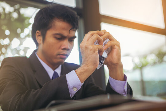 Serious businessman crumpled paperwork, nervous from business disappointed and seriously by bad business results. Selected focus