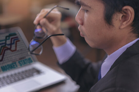 Tired businessman taking off glasses with eye pain during working and reading paperwork in office. Selected focus