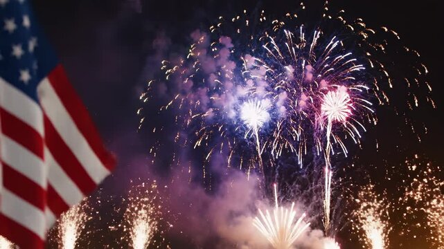 Fireworks display over American flag at night