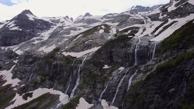 Majestic sofia waterfalls cascading down a rocky mountainside with melting snow. Breathtaking natural landscape in the caucasus mountains