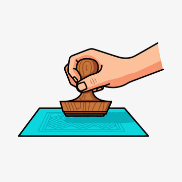 Hand Holding a Rubber Stamp Above a Blue Ink Pad