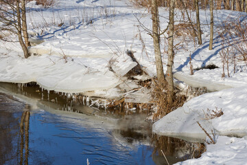 Melting river ice on snowy bank in winter © Maryia