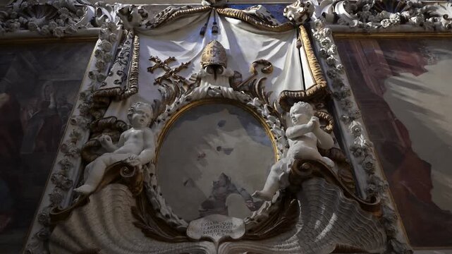 Detailed sculptures and paintings of heavenly angels decorate the historic stone architecture and high vaulted ceilings of the ancient gothic sanctuary in soft natural light