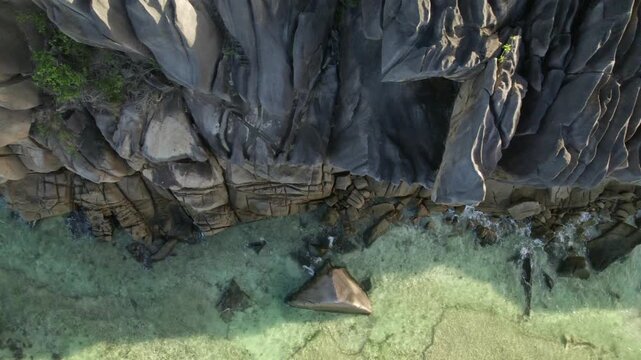 Drone of huge granite rock boulders near the beach, calm water, Anse grosse roche, La Digue, Seychelles 005 30fps