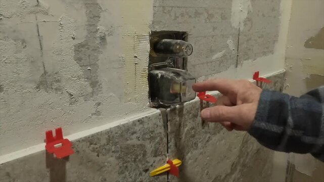 Women pointing out tile and shower diverter 3