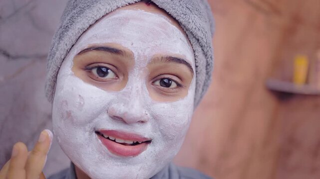 Close up shot of a woman applying natural face pack during her skincare routine indoor.