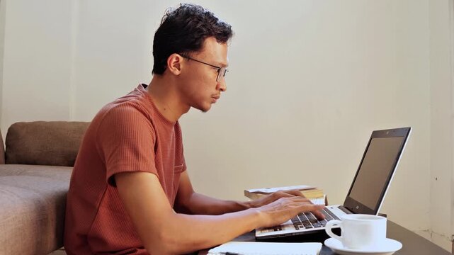 asian man working on laptop seriously