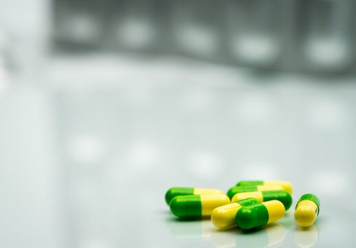 Green and yellow tramadol capsule pills. Opioid analgesic for cancer pain management. Drug abuse risk in teenagers, pharmaceutical safety and controlled substance awareness. Healthcare safety.