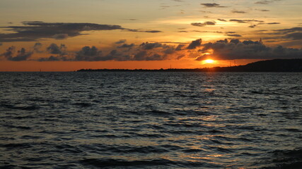 Obraz premium Sun sets over calm ocean waters