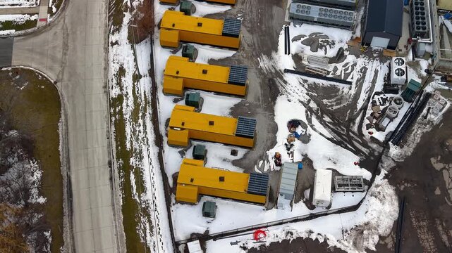 Aerial view of yellow industrial power generators and data center equipment in winter