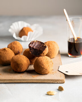 Chocolate truffles dusted with cocoa powder with coffee and cardamom on table