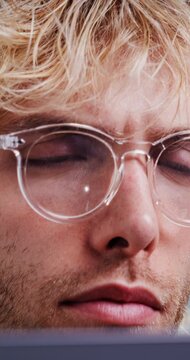 Confused, man and glasses with laptop in office for research, finance report and investigation. Person, eyewear and pc reflection for financial assessment, risk management and compliance information