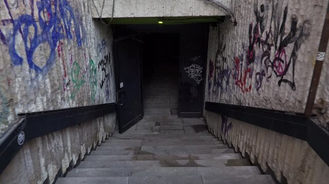 4k video of going down the stairs of an underpass (tunnel) in the city center of Sofia, Bulgaria, the Balkans in Eastern Europe. It is covered with graffiti and looks in decay and a little ruined.