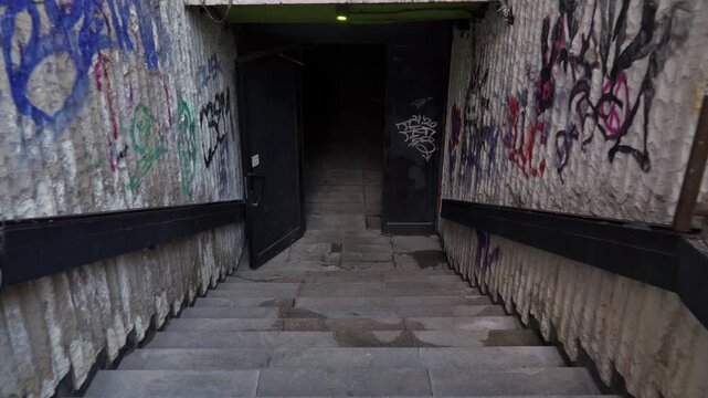 4k video of going down the stairs of an underpass (tunnel) in the city center of Sofia, Bulgaria, the Balkans in Eastern Europe. It is covered with graffiti and looks in decay and a little ruined.