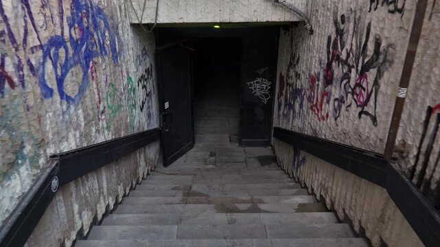 4k video of going down the stairs of an underpass (tunnel) in the city center of Sofia, Bulgaria, the Balkans in Eastern Europe. It is covered with graffiti and looks in decay and a little ruined.