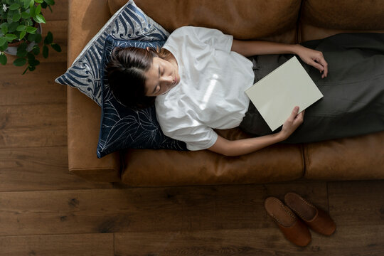 ソファーで居眠りする40代日本人女性