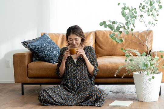 リビングでコーヒーを飲む40代日本人女性