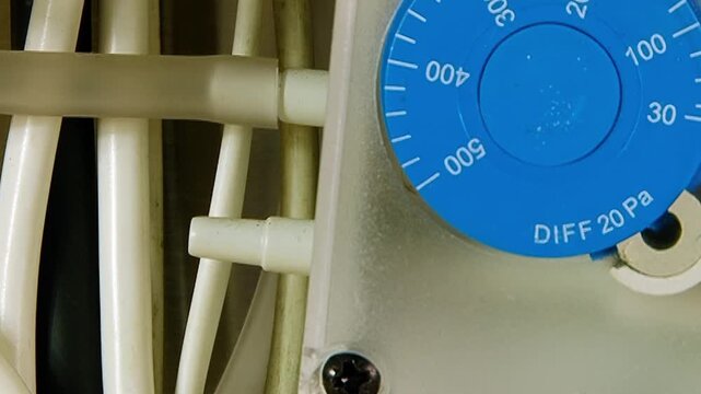 An intricate air filtration system operates with precision. A blue dial prominently displays the vital differential pressure.