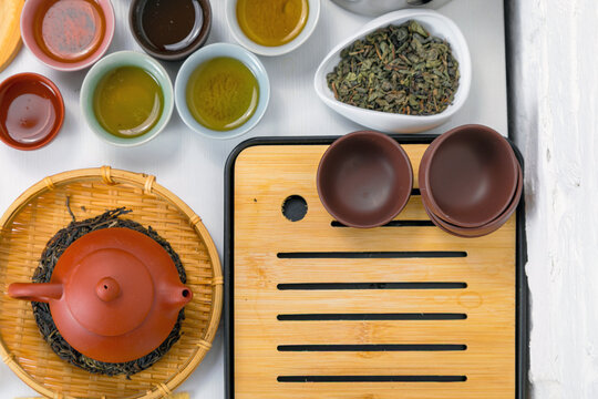 Traditional tea ceremony set with Yixing teapot and bowls on chaban board. Healthy herbal drink preparation for meditation and wellness. Zen culture and ancient tea traditions concept