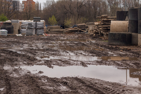 Numerous traces of various equipment at a construction site in the mud and puddles after rain