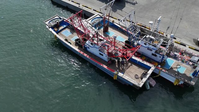 Static aerial view of a medium-sized fishing vessel docked at the port [4K]