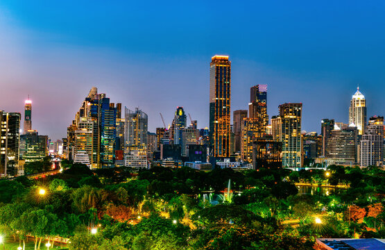 Bangkok city skyline at night with Lumphini Park green space from Dusit Central Park viewpoint, Thailand.