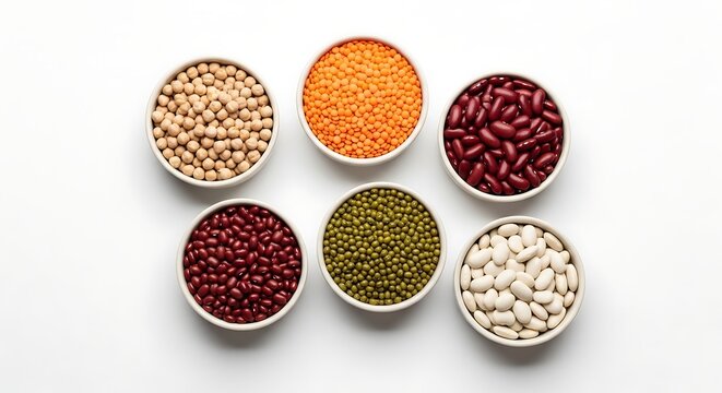 Top view of six bowls with various types of legumes, including chickpeas, red lentils, kidney beans, adzuki beans, mung beans, and cannellini beans isolated on white background