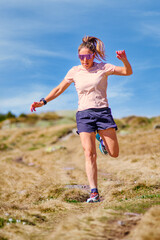 Fototapeta premium Female Trail Runner Jumping on Rocky Path