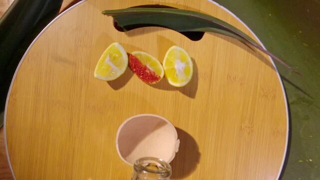 Pouring traditional mexican mezcal in a jicara with lime and salt