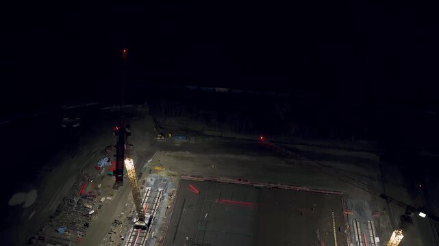 Luftbildaufnahme einer Baustelle bei Nacht