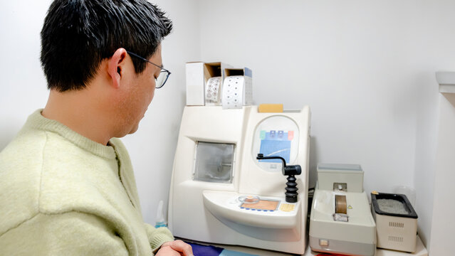 Optician inspecting optical equipment for precision work