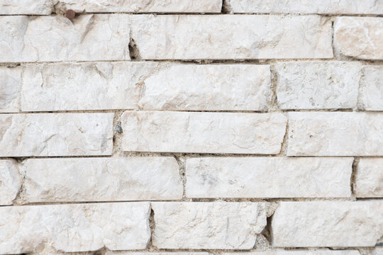 Rough stone wall texture background in natural light